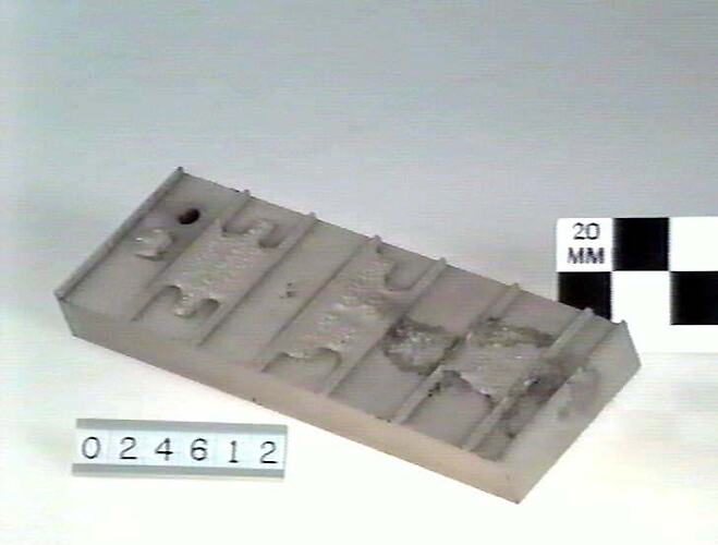 Rectangular metal block with inscription.
