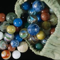 Colourful marbles in a green bag