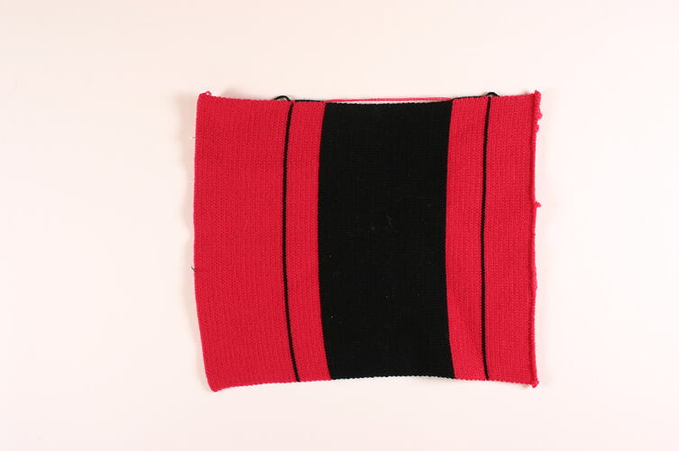 Rectangle of knitted magenta and black wool.