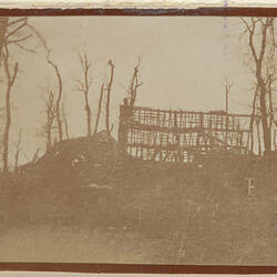 Remains of a damaged structure, with bare trees surrounding.