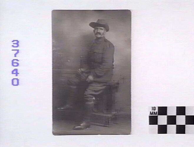 Studio portrait of seated army soldier.
