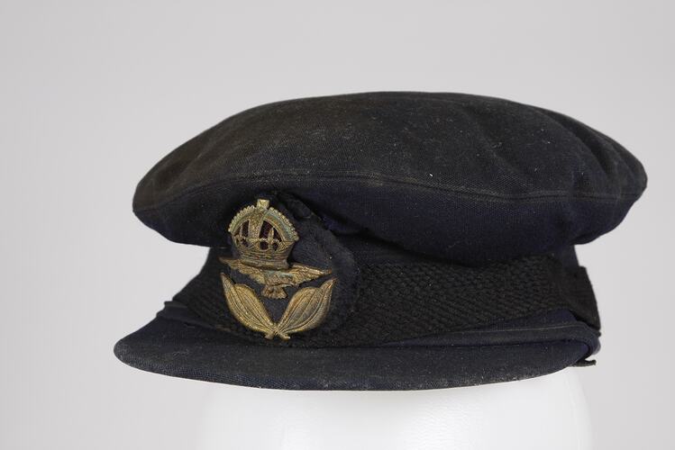 World War II RAAF officer's peaked cap with gold braid insignia. Chin strap and side buttons missing.