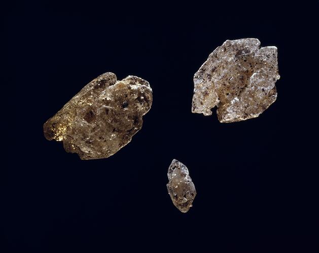 Three speckled cream and black mineral specimens.