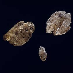 Three speckled cream and black mineral specimens.