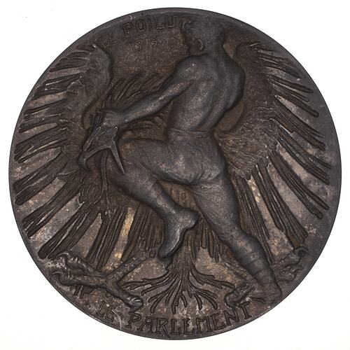 Round medal with man fighting eagle.