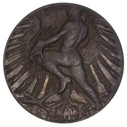 Round medal with man fighting eagle.