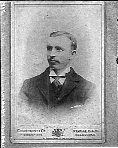 Man with moustache wearing suit and neck tie.