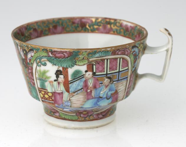 Decorative teacup with colourful Chinese scene that includes three figures.