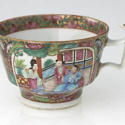 Decorative teacup with colourful Chinese scene that includes three figures.