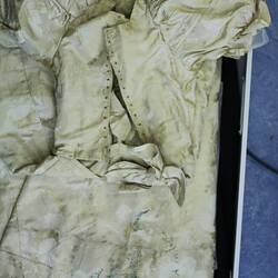 Cream dress showing back details with staining.