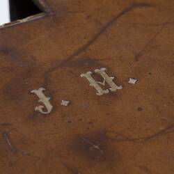 Detail of tan leather camera carry case. Initials J.H.