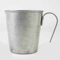 Tin measuring jug with handle.