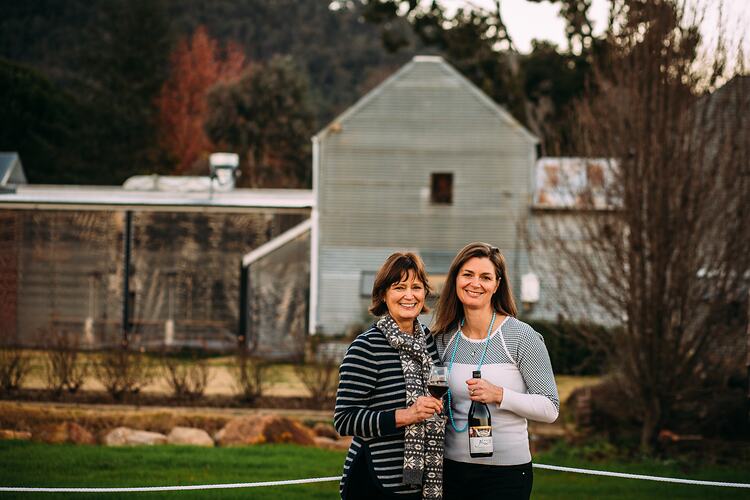 Two women standing in front of winery building.