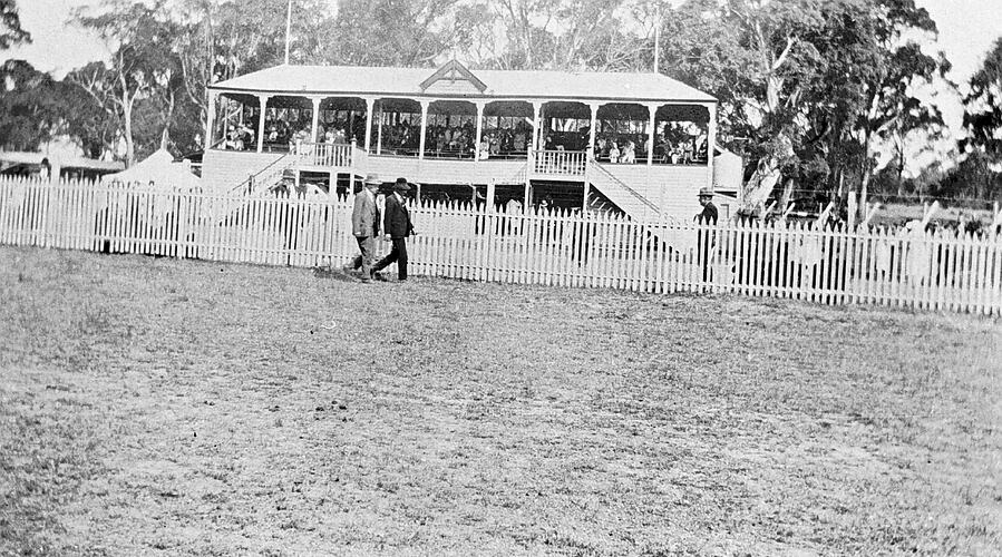 Negative Two Men Walking Along the Course at The Grandstand at the