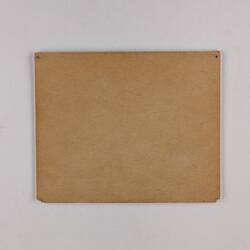 Plain back of a brown exhibition label.