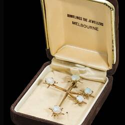 Back of white opal and gold brooch the shape of the southern cross. In box.