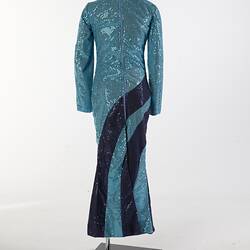 Back view of aqua full-length sequin dress with navy swirls. Long sleeves, high neckline.