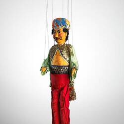 Front view of male puppet in bright clothing.