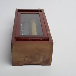 Wooden rectangular box. Glass section on top on box. End view.