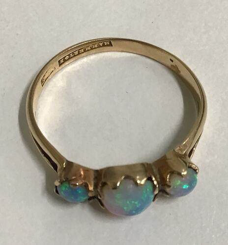 Gold ring with three round opals. Centre stone is larger.
