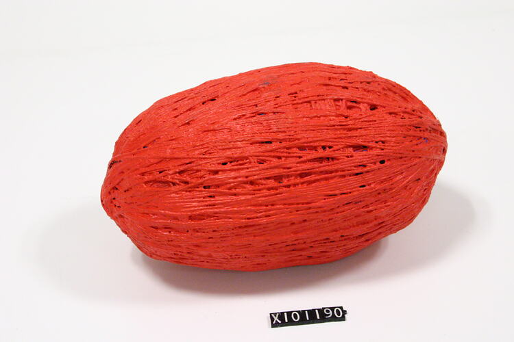 Oval shapped ball of string painted red.