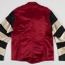 Red riding jacket with red buttons. Black and white hoops on sleeves. Short stand up red collar. Flat.