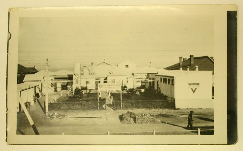 Man walking along road past returned soldiers house.