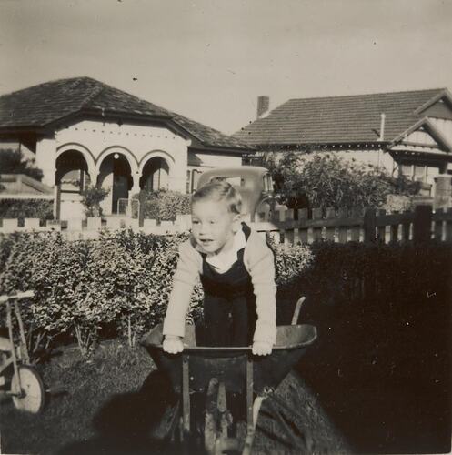Digital Photograph - Boy Playing in Wheelbarrow, Front Garden, Essendon, 1949