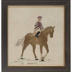 Framed embroidery of race horse.