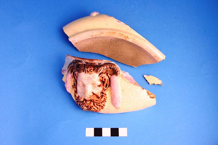 Three shards of broken ceramic pot, one with horned male head.