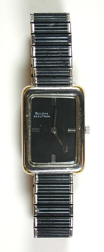 Watch, black and silver rectangular face and flexible band.