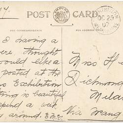 Reverse side of postcard with handwriting and a pink stamp.