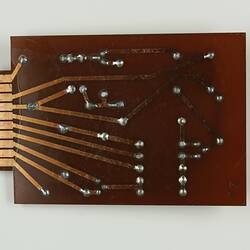 Amber coloured circuit board, soldered points, copper tracking.