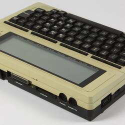 Small cream portable computer with black type keys.