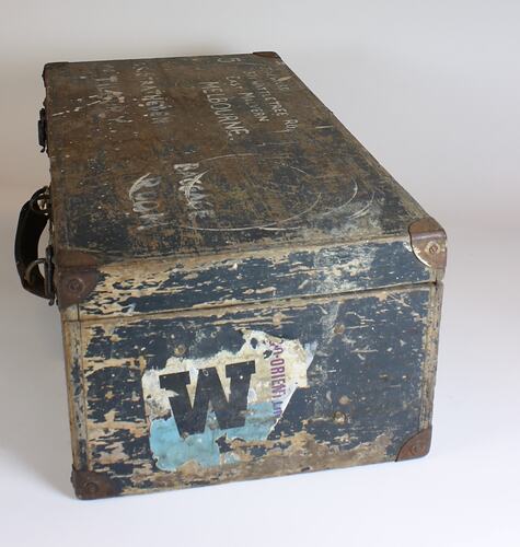 Wooden trunk with metal clasps and leather handle.