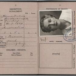 Open passport with off-white pages. Printed and handwritten text. Black and white photo.