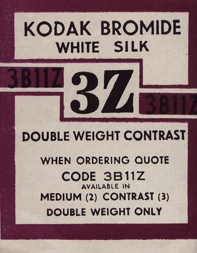 Maroon and white paper label with printed text.