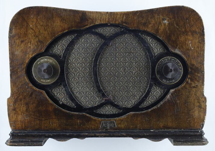 Curved wooden radio with two tuning knobs either side of central circular pattern.