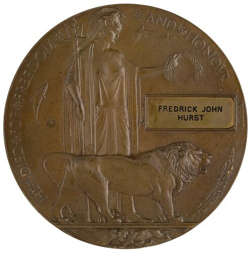 Bronze coloured medal with lion and woman holding trident and wreath.