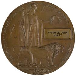 Bronze coloured medal with lion and woman holding trident and wreath.