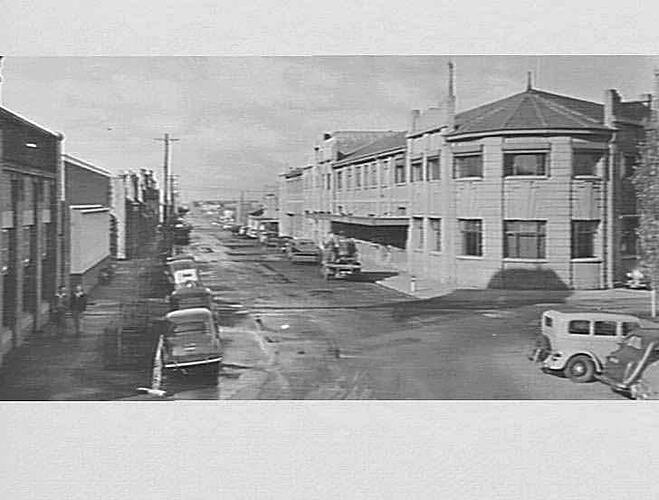 Street with factory and other buildings.