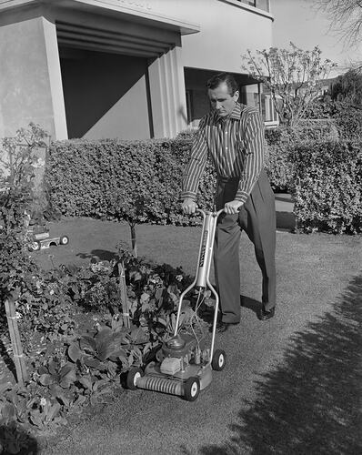 Man mowing lawn. House in background.