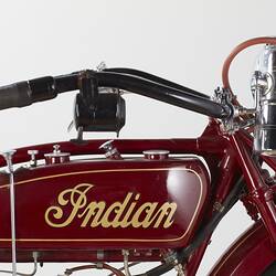 Red motor cycle, handlebars and tank with yellow lettering detail. Right view.