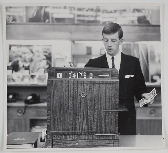 Man standing behind a sales counter.