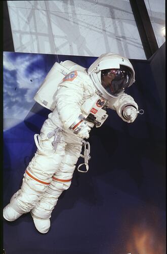 Life-size male mannequin in white astrounaut suit and helmet.