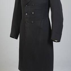 Gentleman's black cotton frock coat, six-button, double-breasted with peaked lapels.