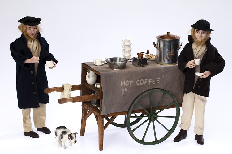 Street cart coffee stall model with two male figurines and a dog.