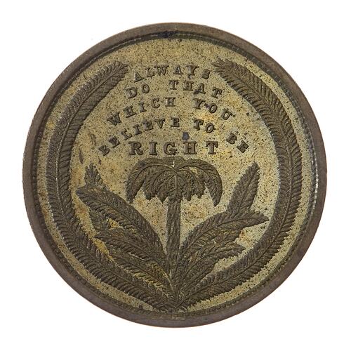 Round bronze coloured coin. Plant motif with wreath border. Text above.