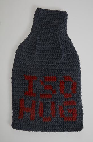 Grey crocheted water bottle cover. Red lettering.