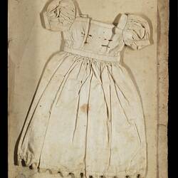 Page 24 of an unbound book with a sewing sample of a white short sleeved doll's dress.